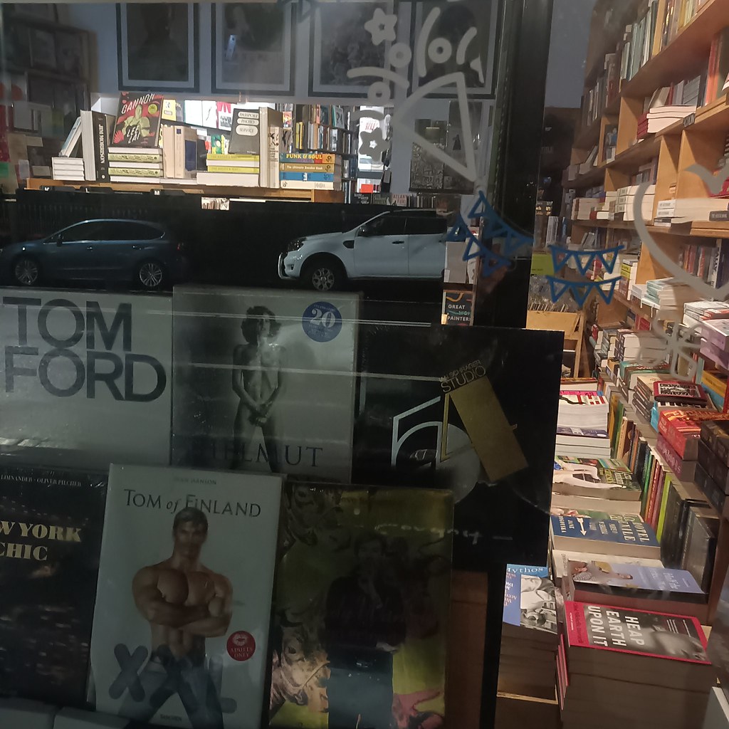 Kitapçı vitrininde Tom Ford kitapları ve gece sokağının büyüleyici yansıması