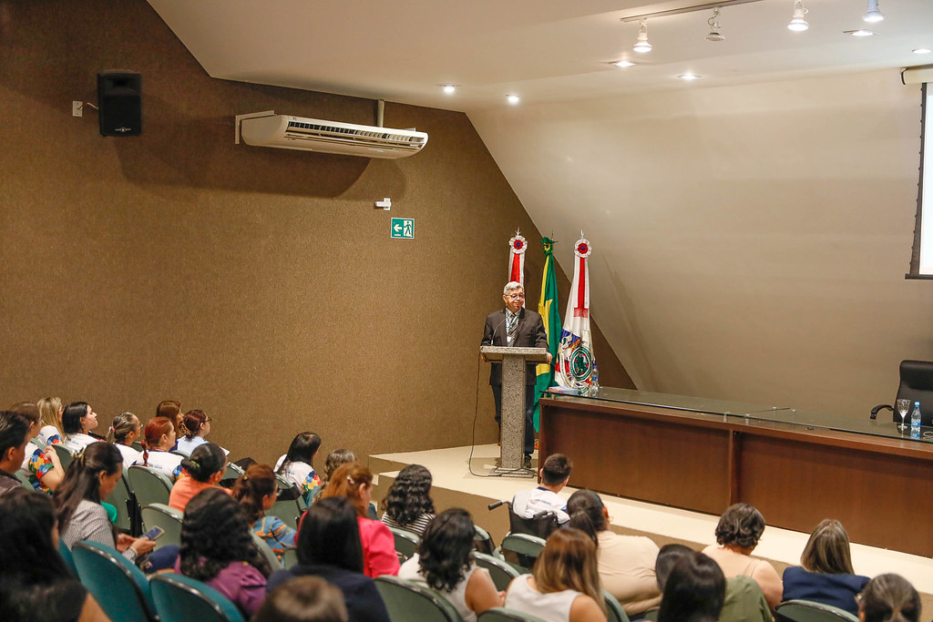 Konferans salonunda profesyonel sunum yapan konuşmacı ve dinleyici kitlesi