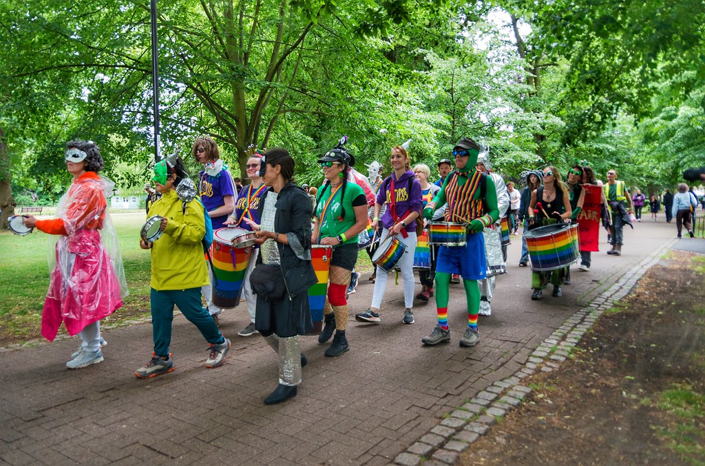 Kostümlü insanların renkli davullarla parkta yaptığı coşkulu festival yürüyüşü Kostümlü insanların renkli davullarla parkta yaptığı coşkulu festival yürüyüşü
