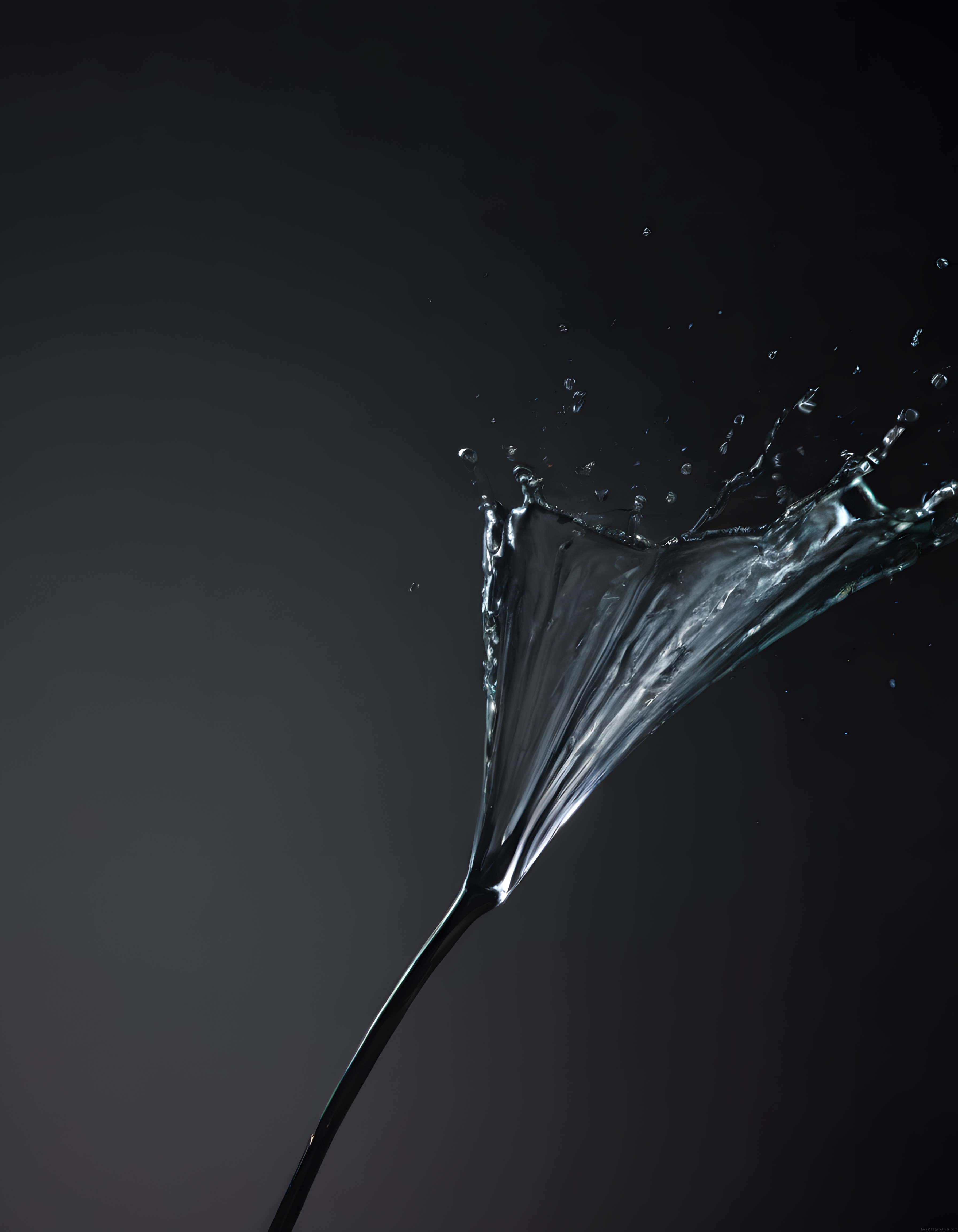 Koyu fonda martini kadehinden fışkıran su zerrecikleri ve etkileyici splash anı