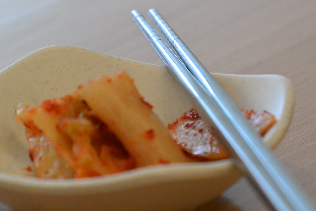 Krem Rengi Kasede Kore Mutfağından Baharatlı Kimchi ve Metal Çubuklar