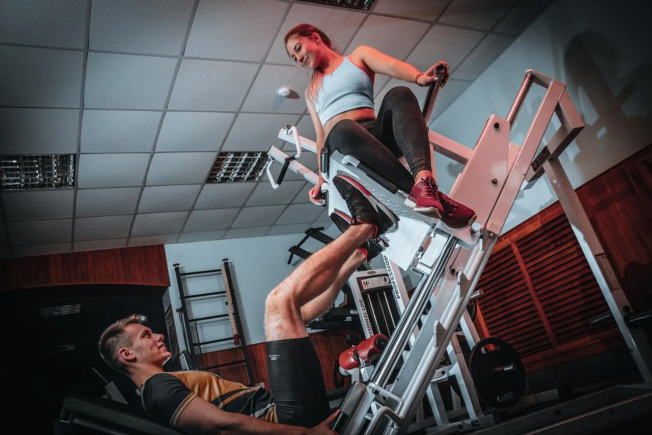 Leg press çalışan atletik erkek ve kadın modeli