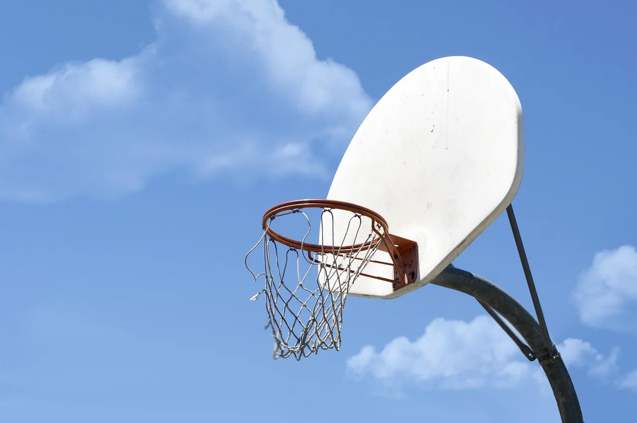 Mavi basketbol topu gökyüzünde çember ve ağ