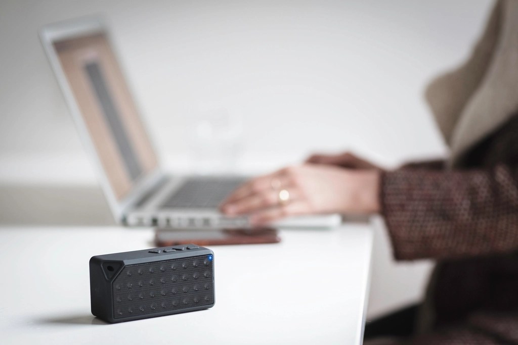 Minimal Beyaz Masada Bluetooth Hoparlör ve Laptop ile Ev Ofisi Çalışması