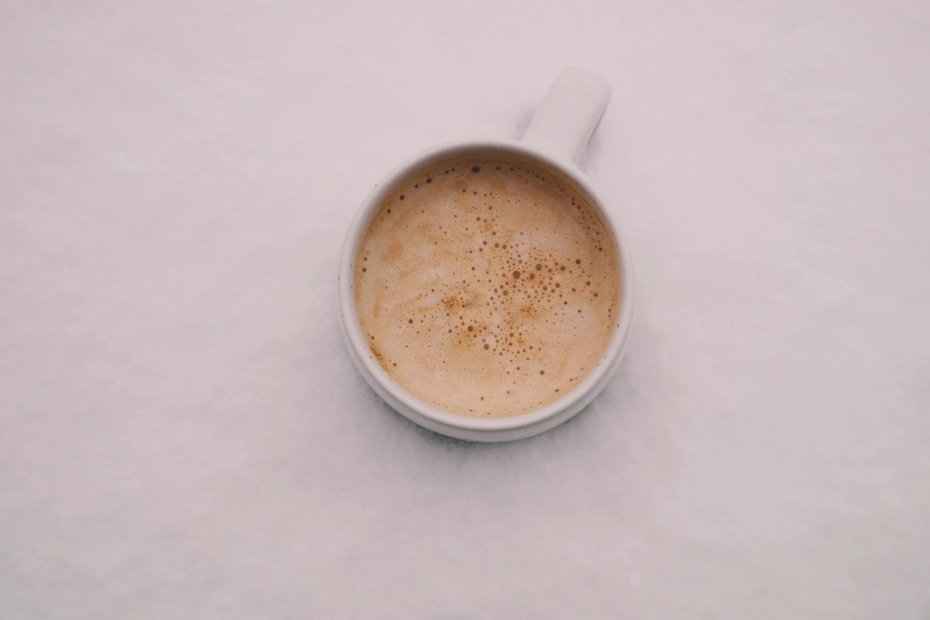 Minimalist Beyaz Fincanda Tarçınlı Sıcak Latte ve Sütlü Kahve Sunumu