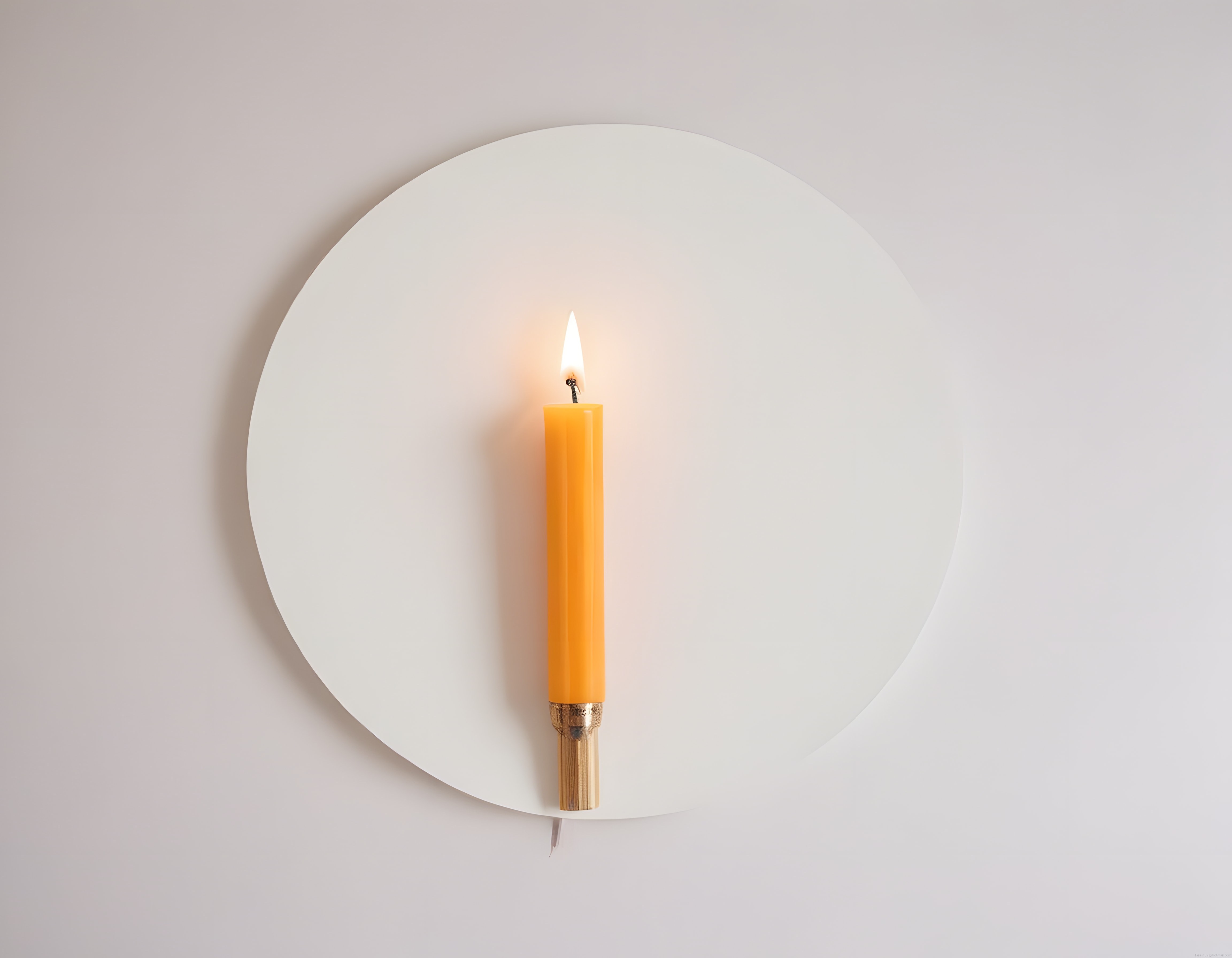 Minimalist Beyaz Pano Önünde Sıcak Işık Saçan Turuncu Mum Görseli