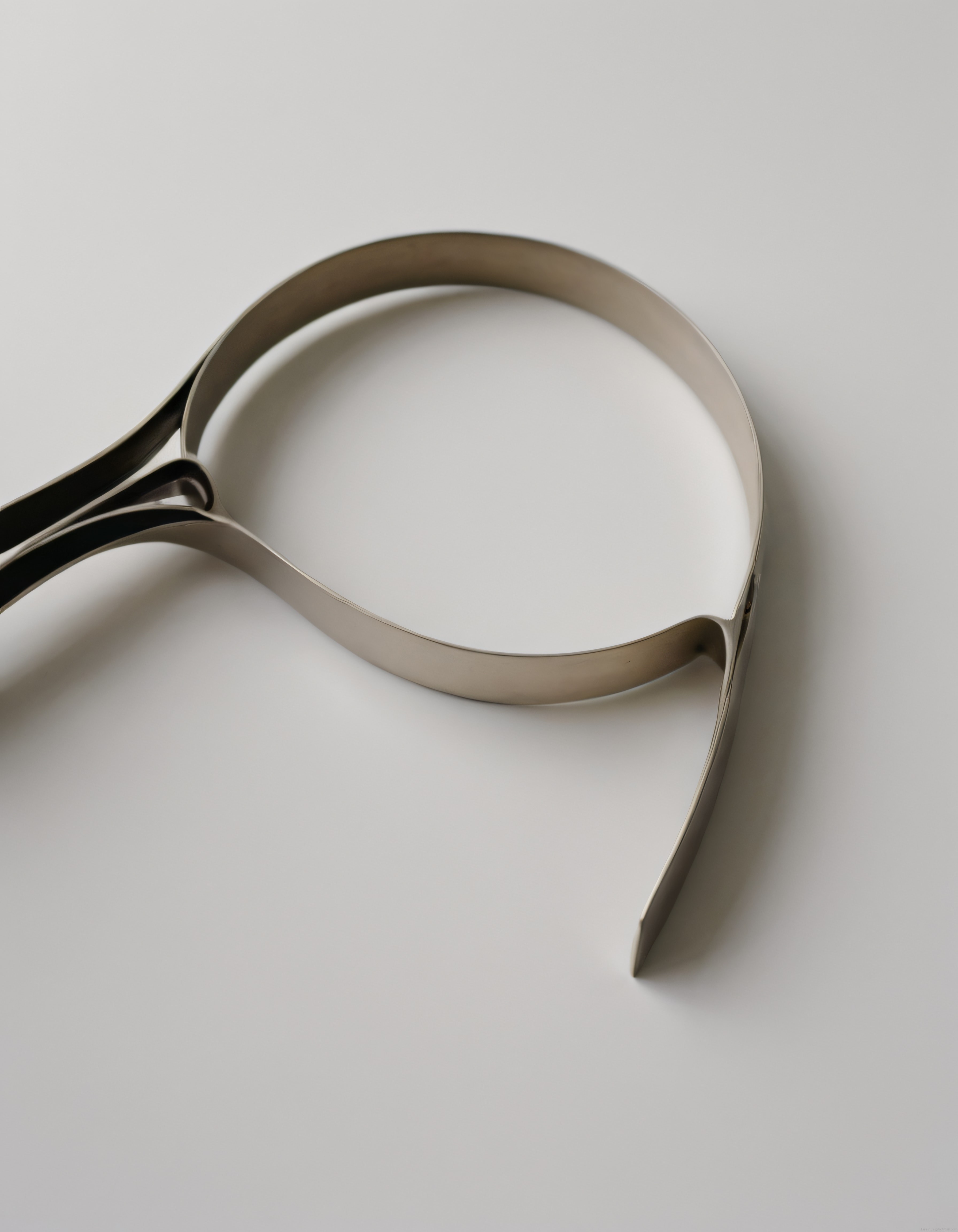 Minimalist Beyaz Zeminde Kıvrımlı Metal Şeritten Oluşan Soyut Heykel