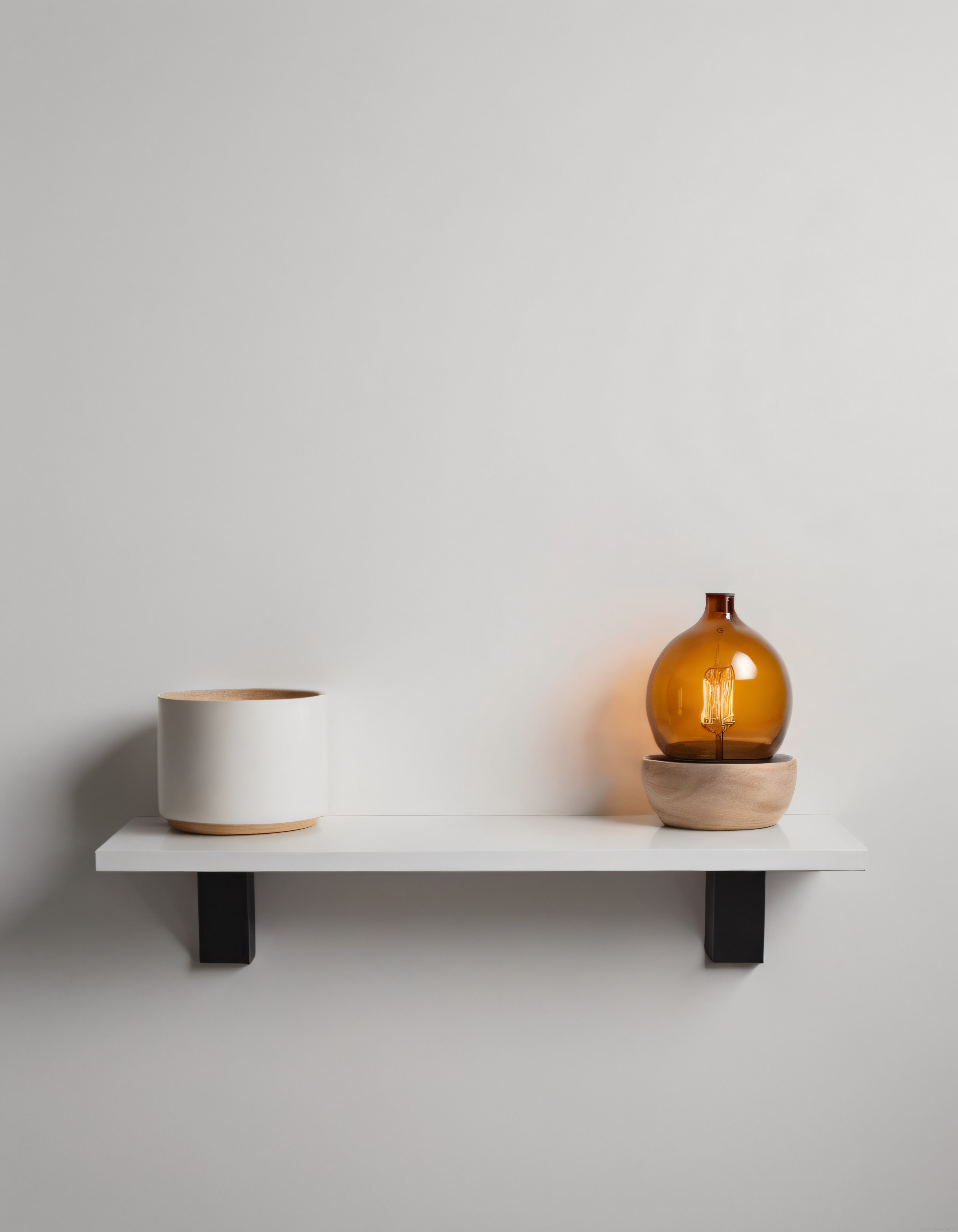 Minimalist Raflı Duvar Ünitesinde Amber Cam Masa Lambası ve Dekoratif Kutu