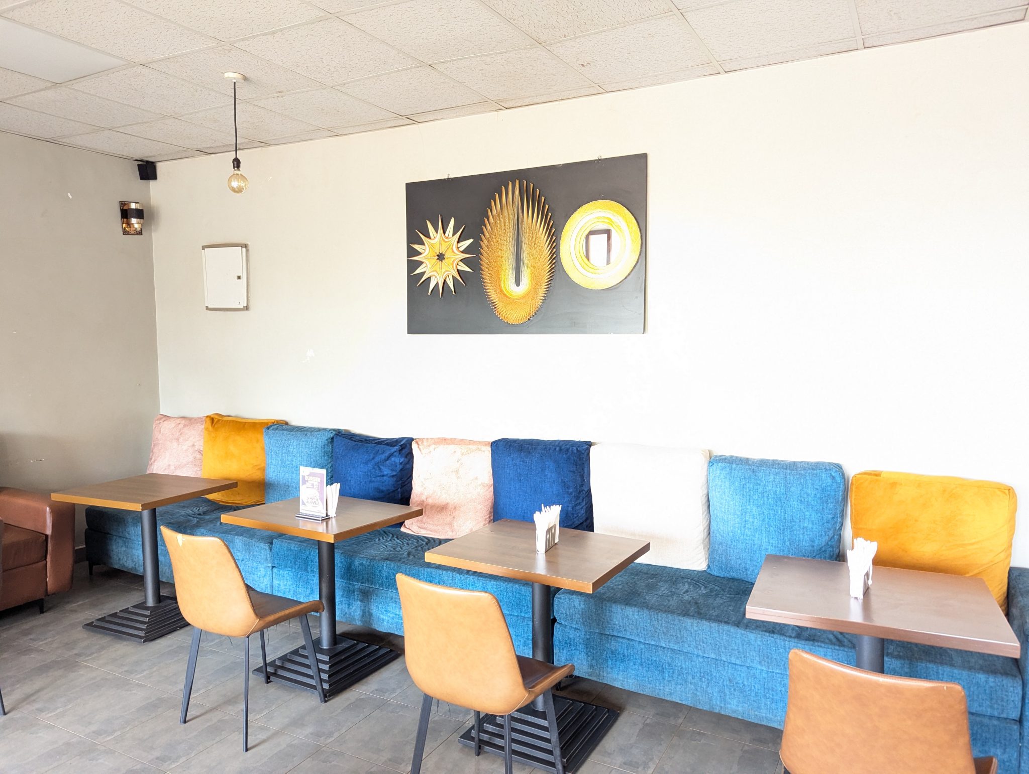 Modern Kafe İç Mekan Tasarımı: Renkli Minderli Rahat Oturma Alanı ve Minimalist Dekor