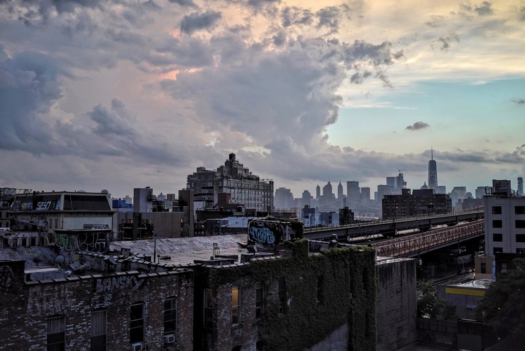 New York'un Çatılarından Gün Batımı ve Uzakta Beliren Gökdelen Silüeti
