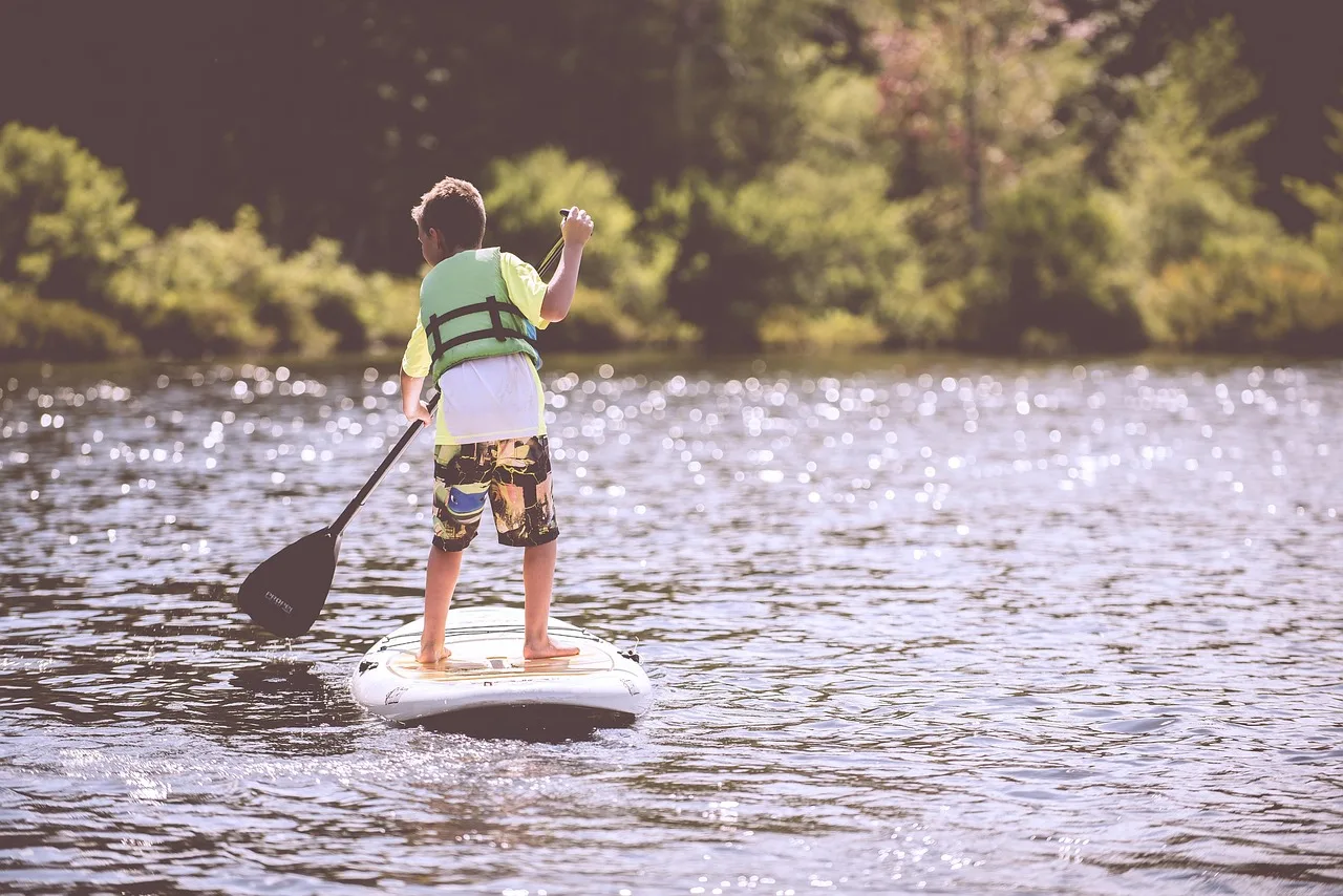Paddleboard ile nehir kıyısında eğlenceli çocuk