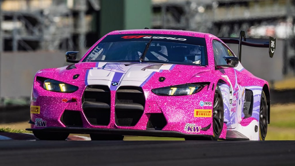 Parlak pembe simli kaplamalı modifiye BMW M4 GT3 yarış otomobili pistte