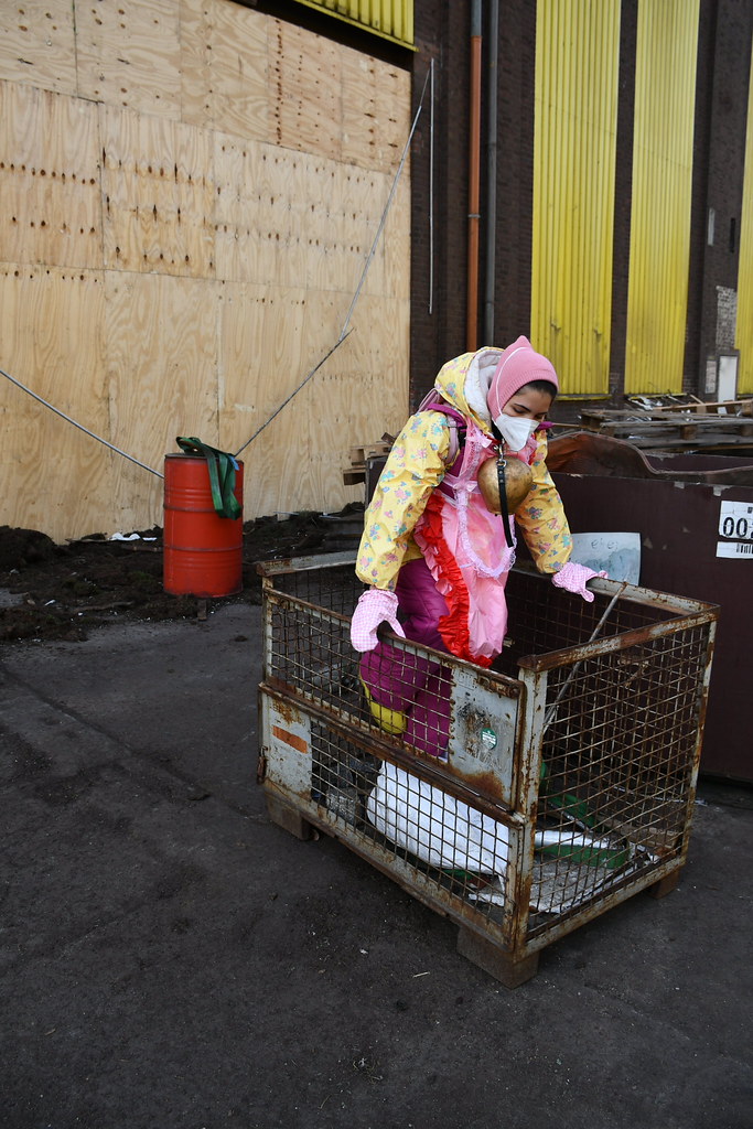 Pembe Eldivenli Çocuğun Endüstriyel Alandaki Renkli ve Çarpıcı Anı