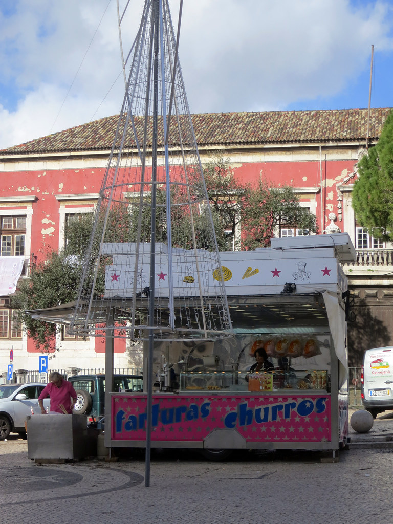 Pembe rengiyle dikkat çeken farturas ve churros sokak satıcısı, tarihi Avrupa meydanında