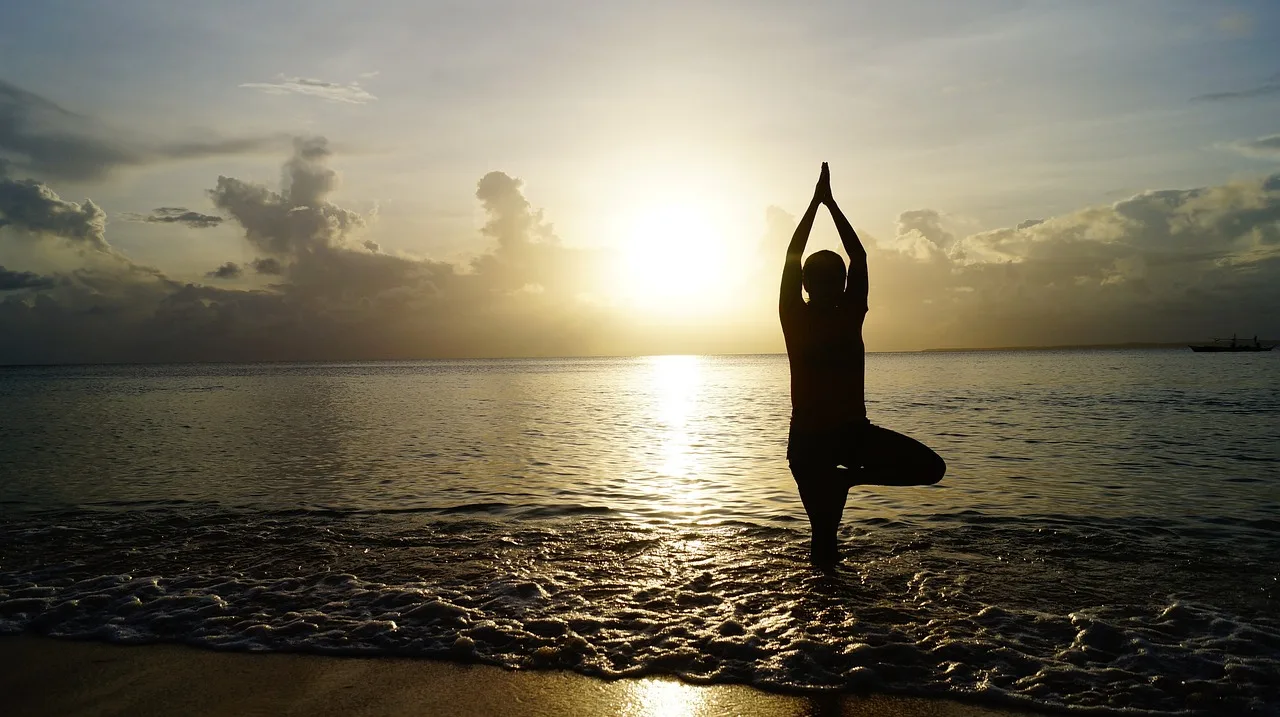 Plajda yoga pozu - gün batımı silueti