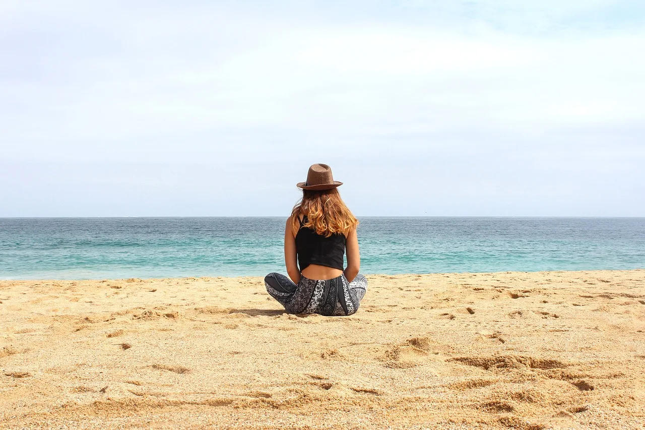 Plajda yoga yapan kadın şapkalı - doğa ve deniz