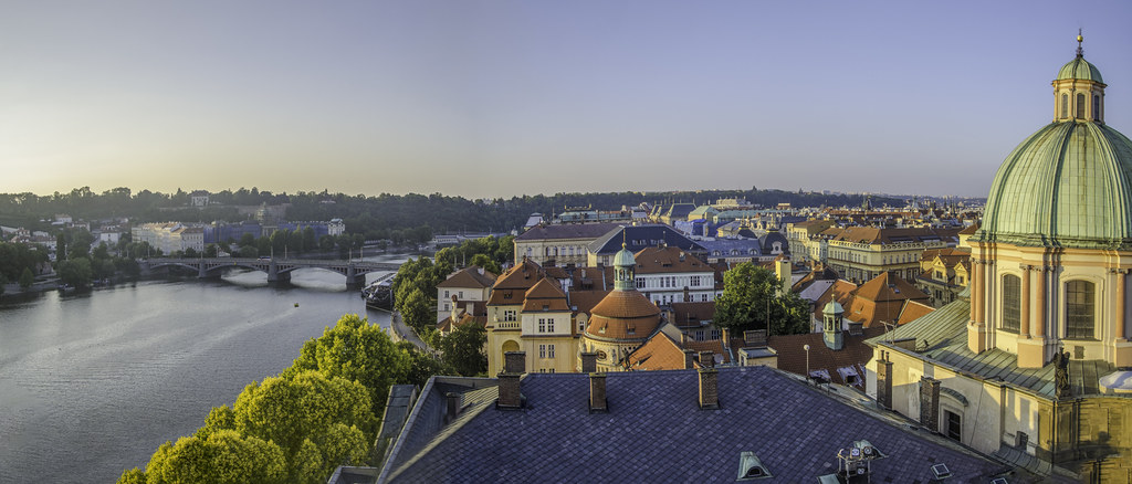 Prag'ın Büyüleyici Panoramik Manzarası: Vltava Nehri, Tarihi Köprü ve Kubbeli Yapılar