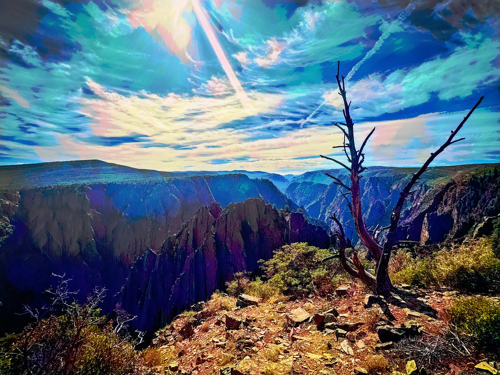 Renkli Bulutlar ve Güneş Işınları Altında Derin Kanyon Manzarası