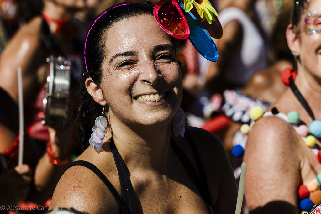Renkli Karnavalda Gülümseyen Kadın ve Arkasındaki Neşeli Festival Kalabalığı