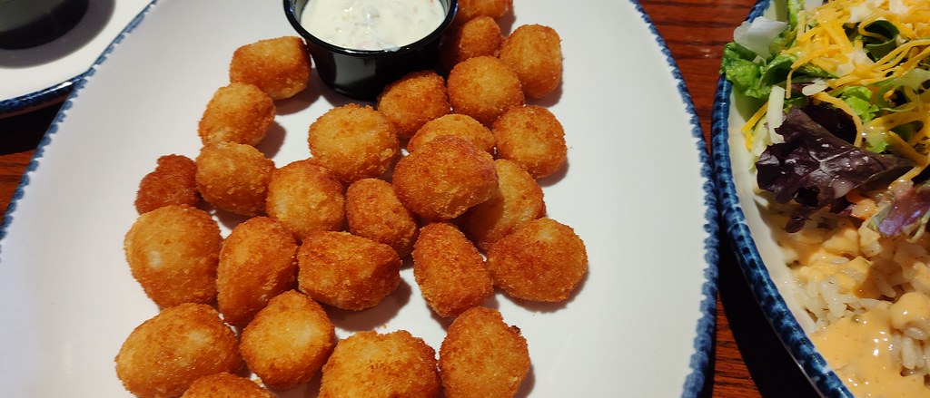 restoranda servis edilen kızarmış çıtır toplar ve yanında taze salata sunumu