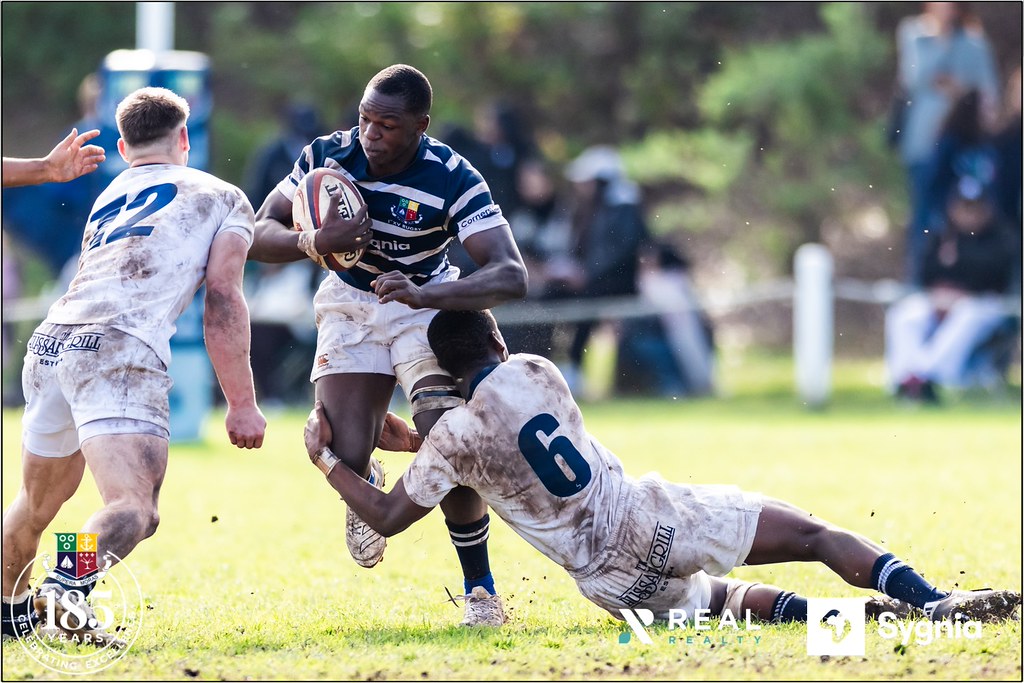 Rugby Maçında Çizgili Formalı Oyuncunun Tackle Anı ve Saha Mücadelesi