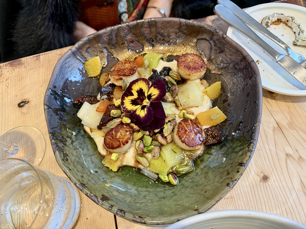 seramik kasede karamelize tarak ve meyvelerle süslenmiş şık restoran tabağı