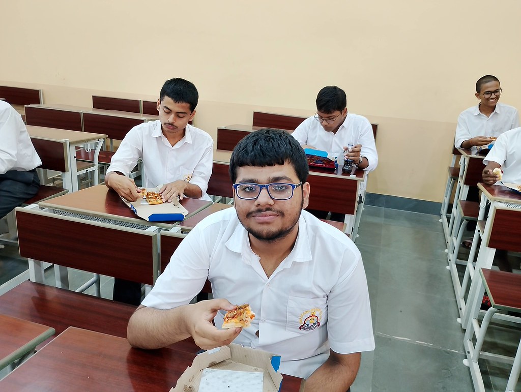 Sınıf ortamında pizza yiyen öğrenciler ve arkadaş canlısı okul atmosferi