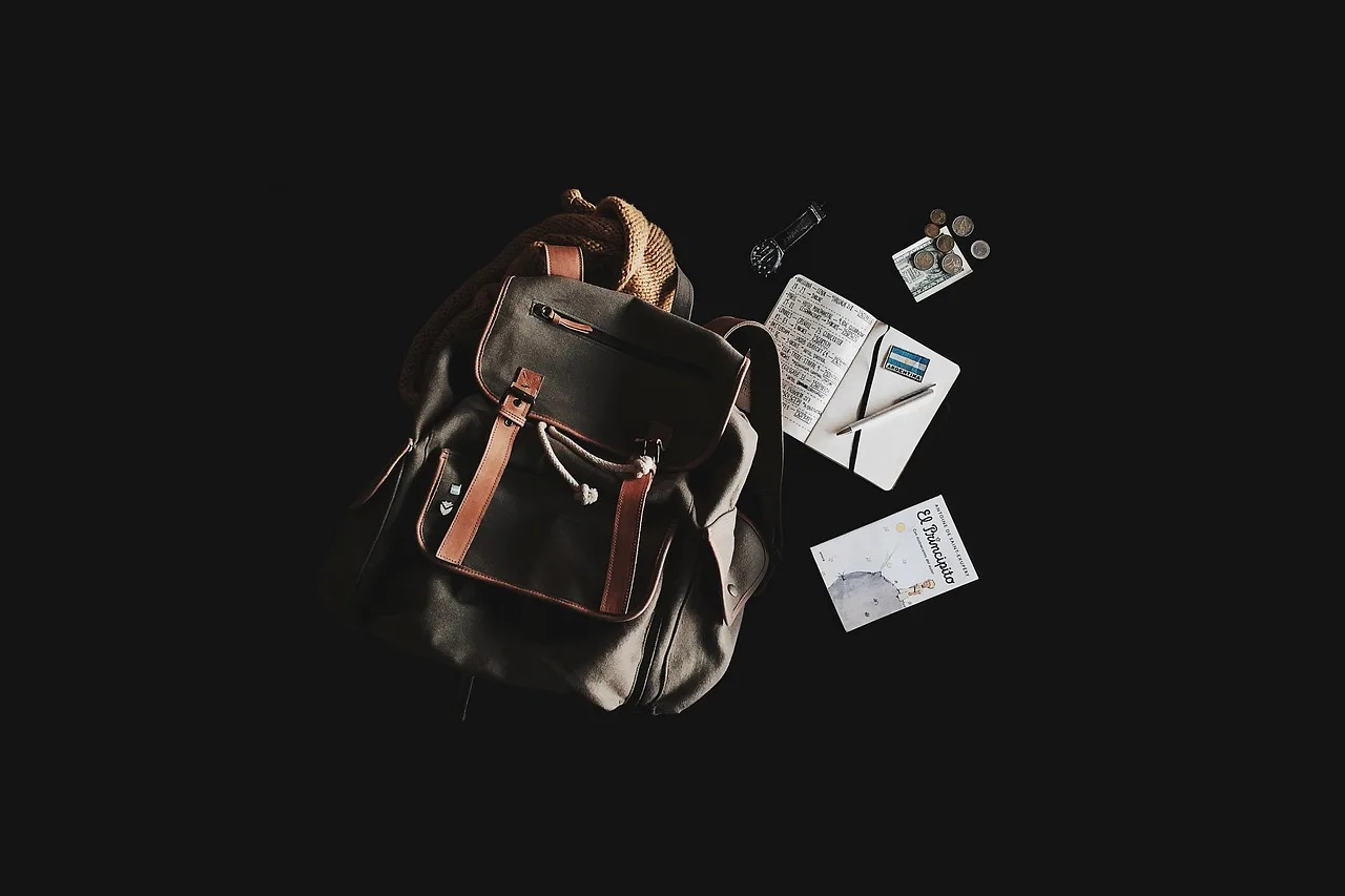 Sırt çantası ve defter flat lay - seyahat teması