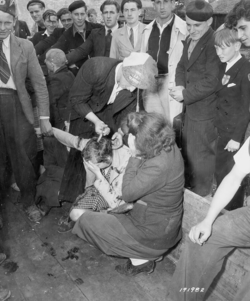 Tarihi Fotoğrafta Kalabalık Arasında Saçları Kesilen Kadın ve Çevresindekiler