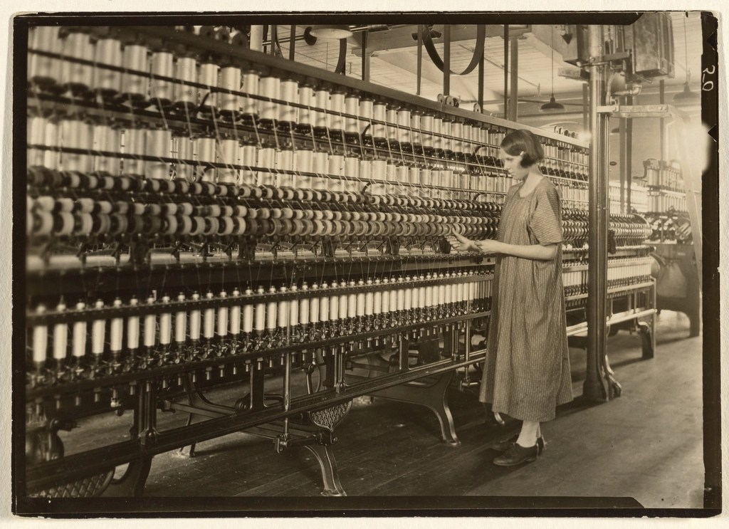 Tarihi Tekstil Fabrikasında Kadın İşçinin Yanında Duran İplik Makineleri