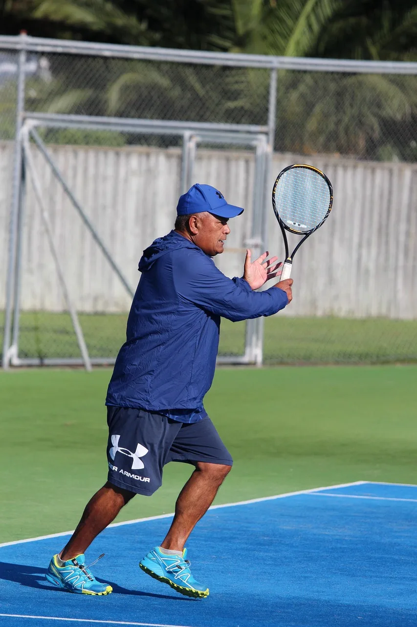 Tenis kortunda koşan erkek sporcu