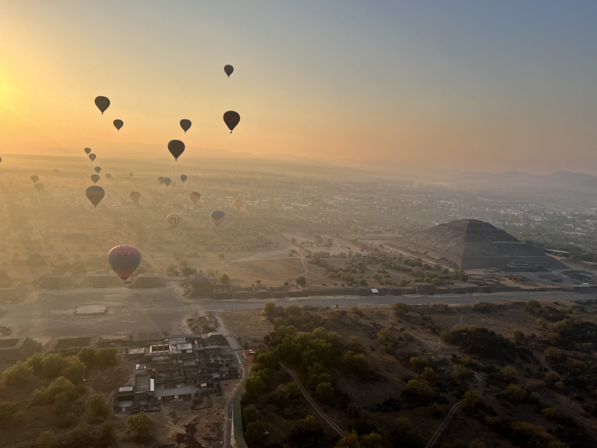 teotihuacan piramitleri üzerinde gün doğumu ve renkli sıcak hava balonları