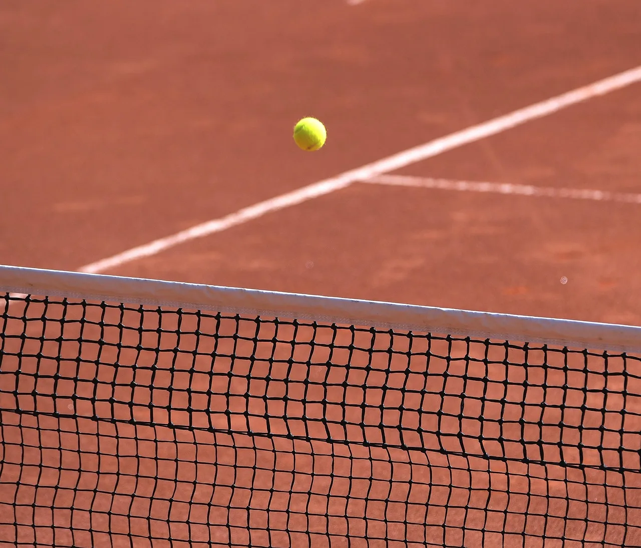 Toprak tenis kortu ve sarı tenis topu yakın çekim
