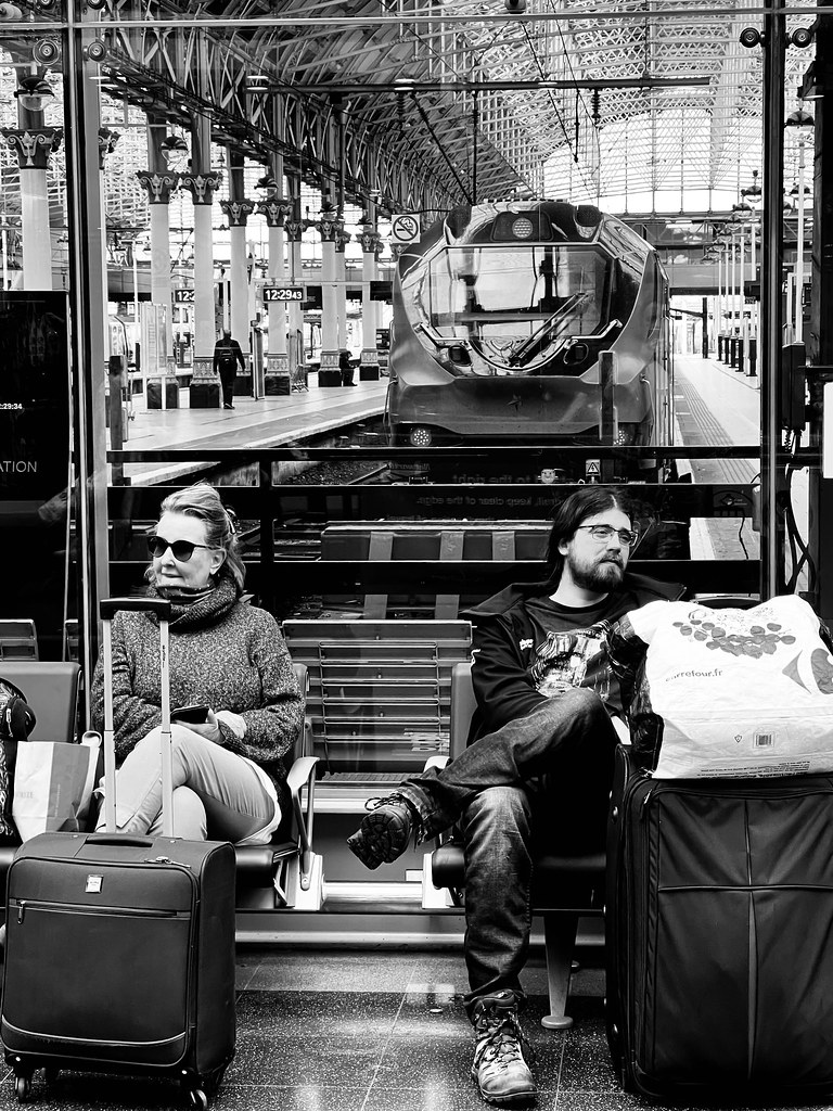 Tren istasyonunda bekleyen yolcular: siyah beyaz sokak fotoğrafı