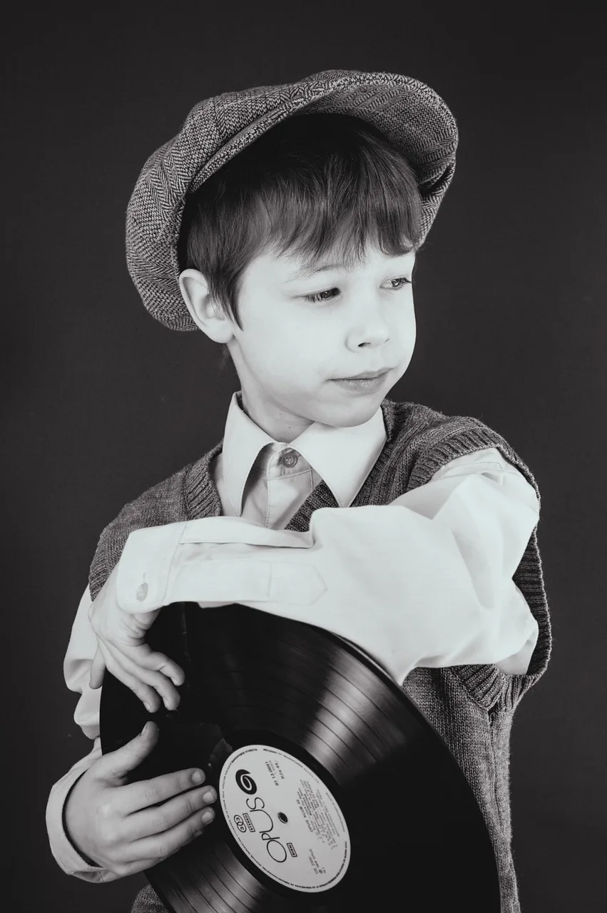 Vinil plak tutan genç çocuk portresi