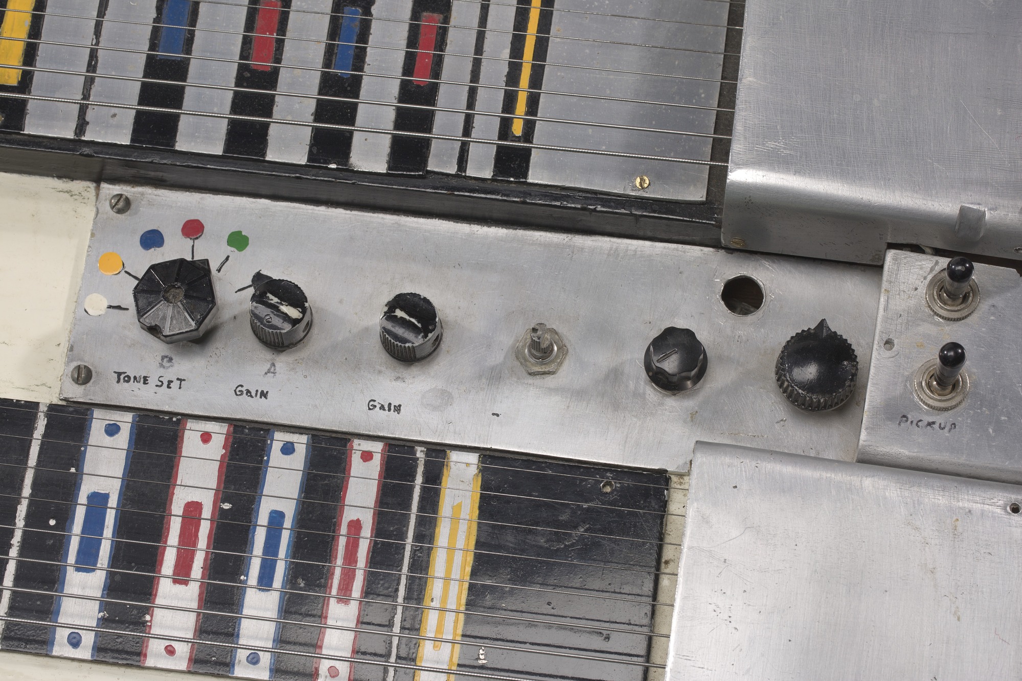 Vintage çelik gitar kontrol paneli ve renkli tellerin yakın plan detayı
