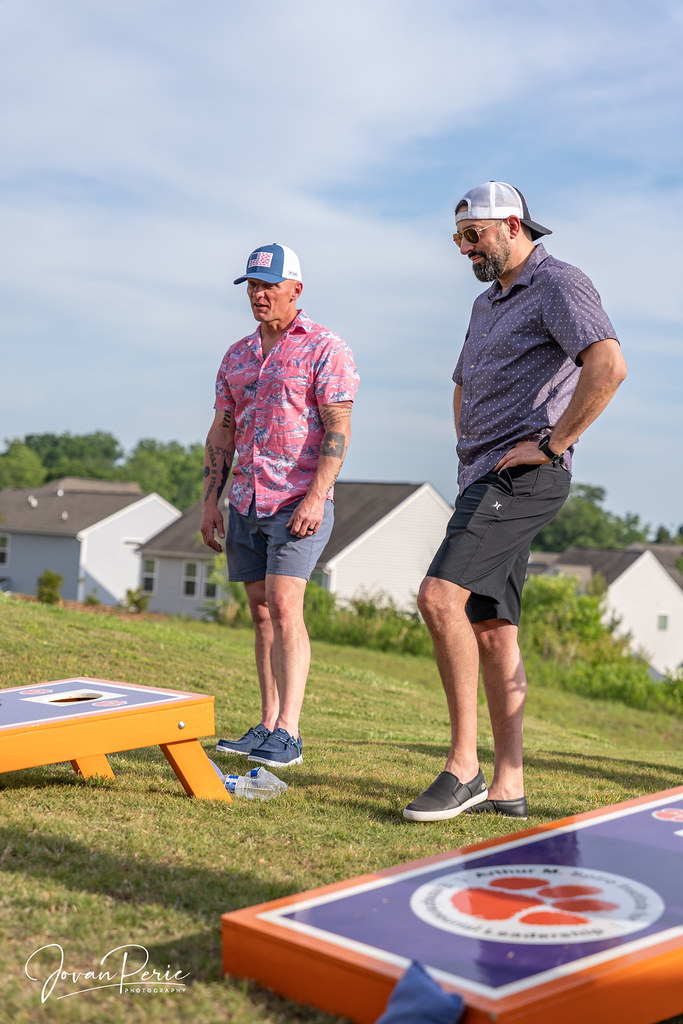 Yaz günü arkadaşlar bahçede cornhole oynuyor, neşeli açık hava etkinliği