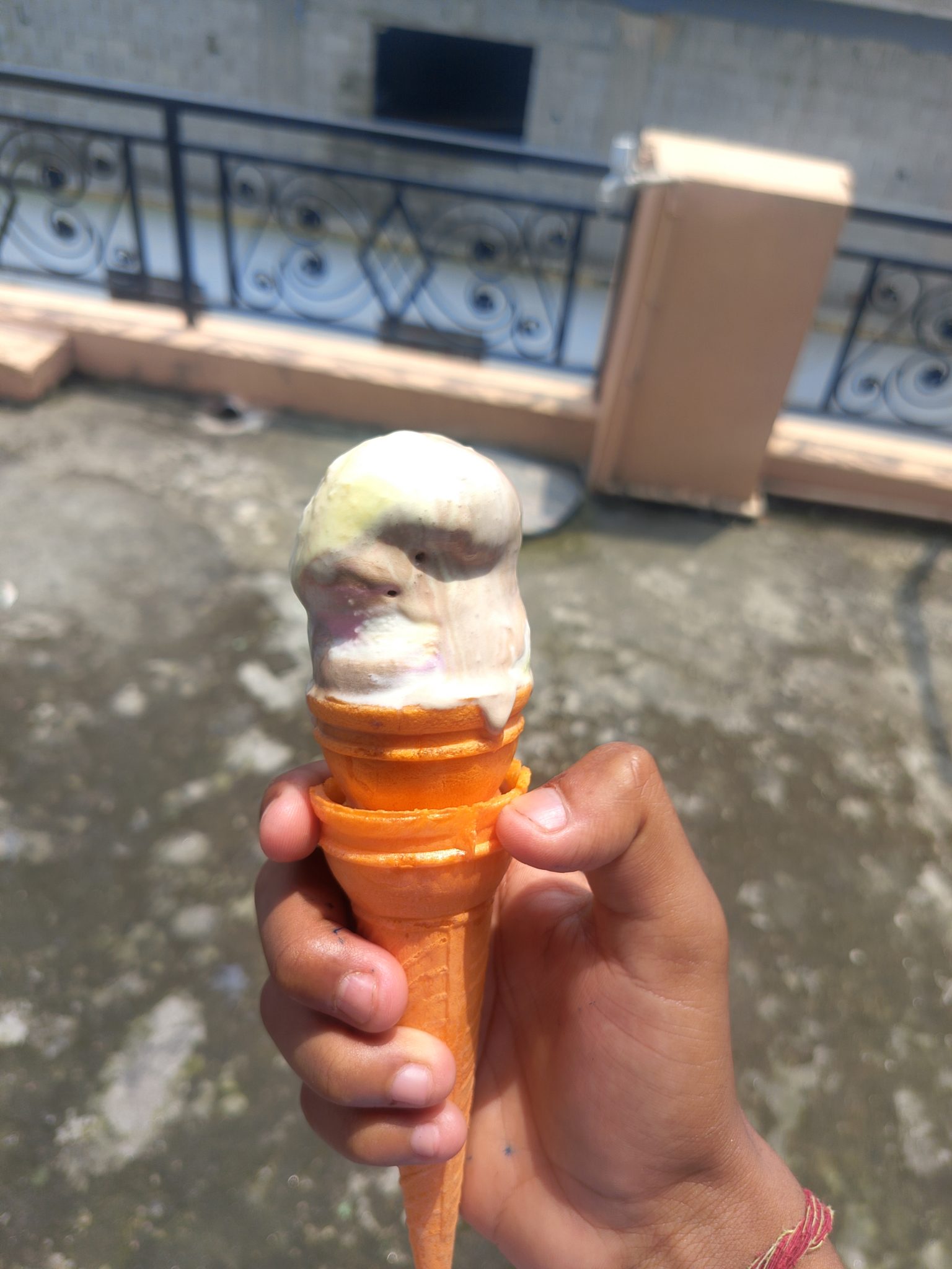 Yaz sıcağında erimiş dondurma külahı tutan el ve enfes tatlı molası