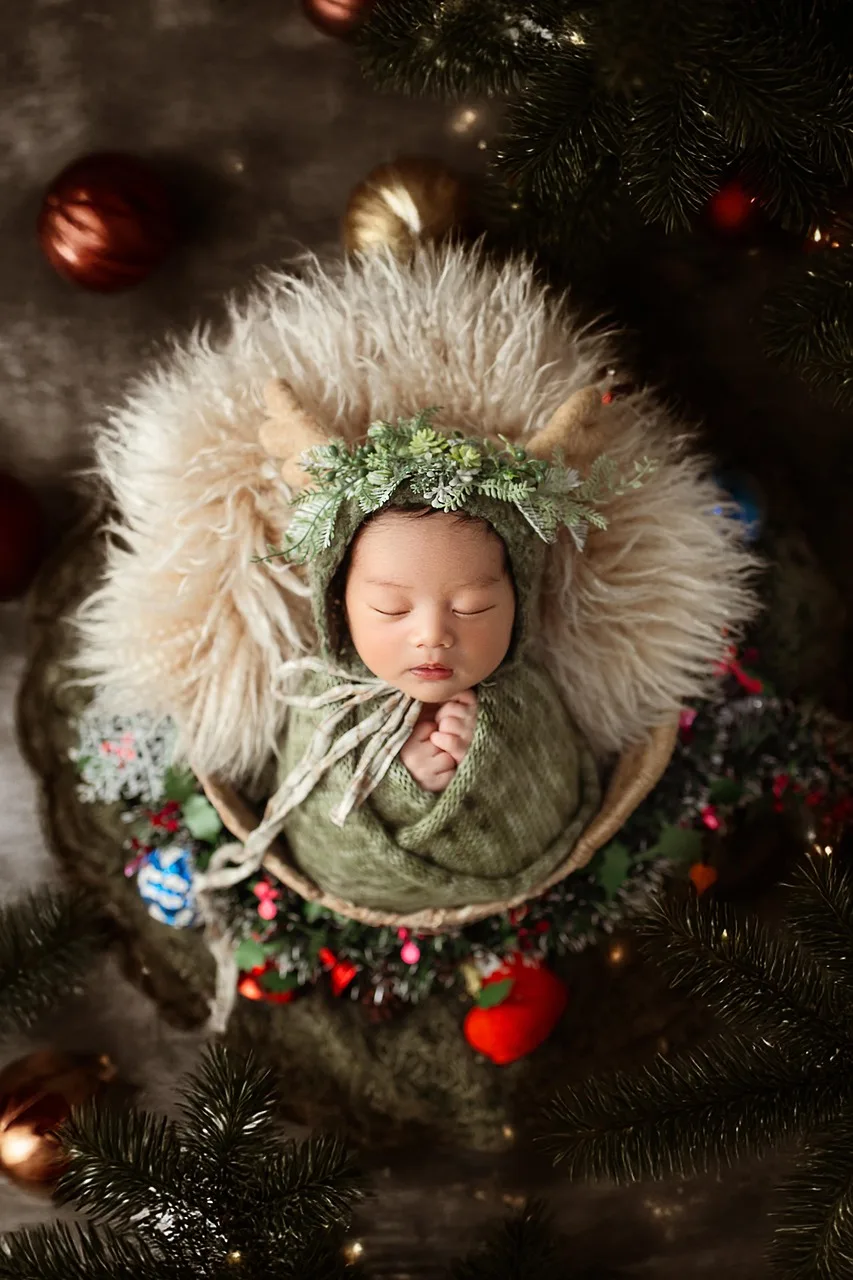 Yeni doğan bebek noel çiçekleri arasında uyuyor