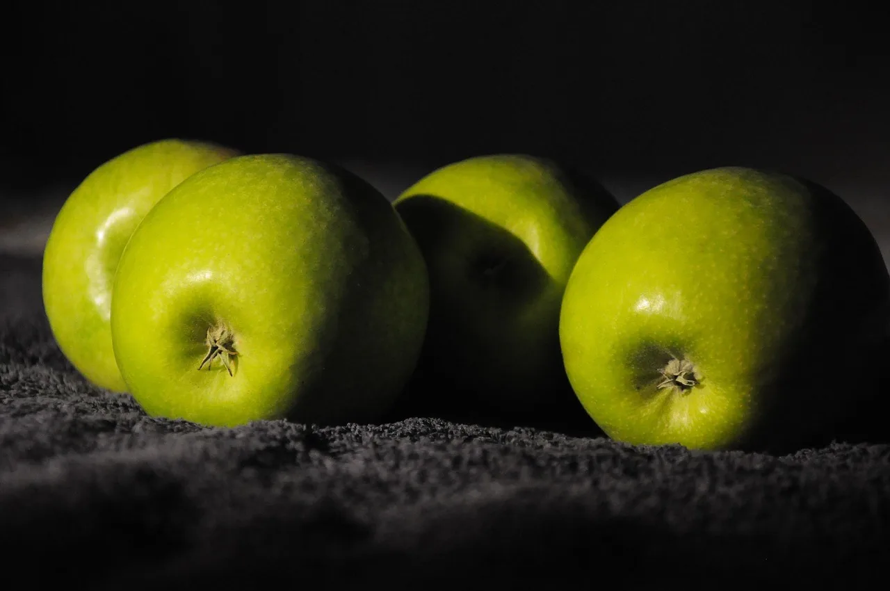 Yeşil elma chiaroscuro stille hayat fotoğrafı
