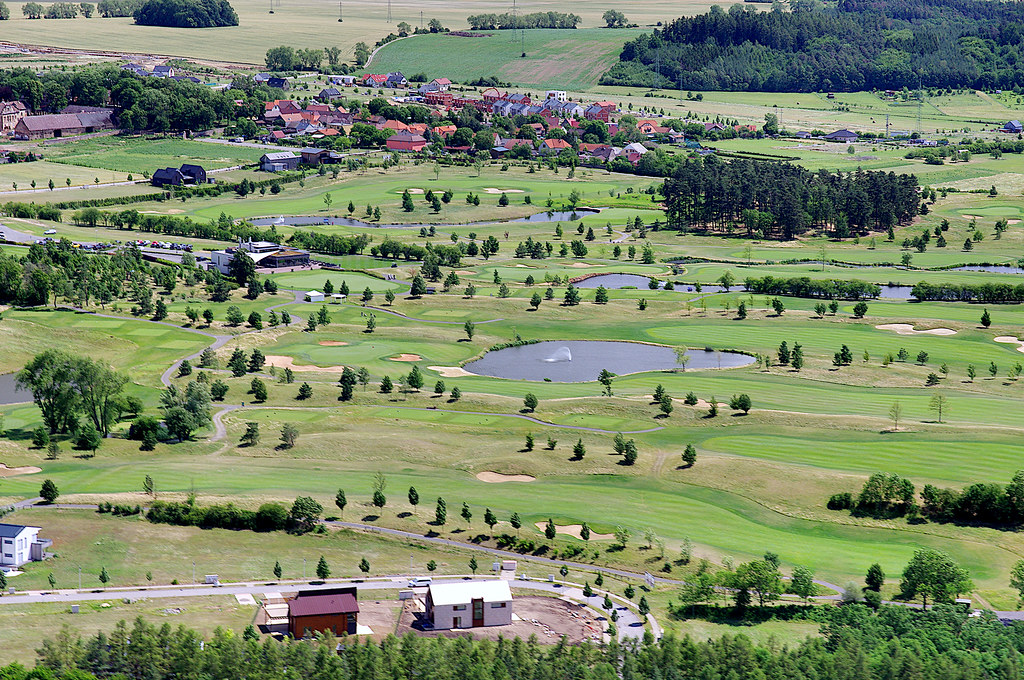 yeşil ovalar arasında kasaba ve göletleriyle havadan golf sahası manzarası